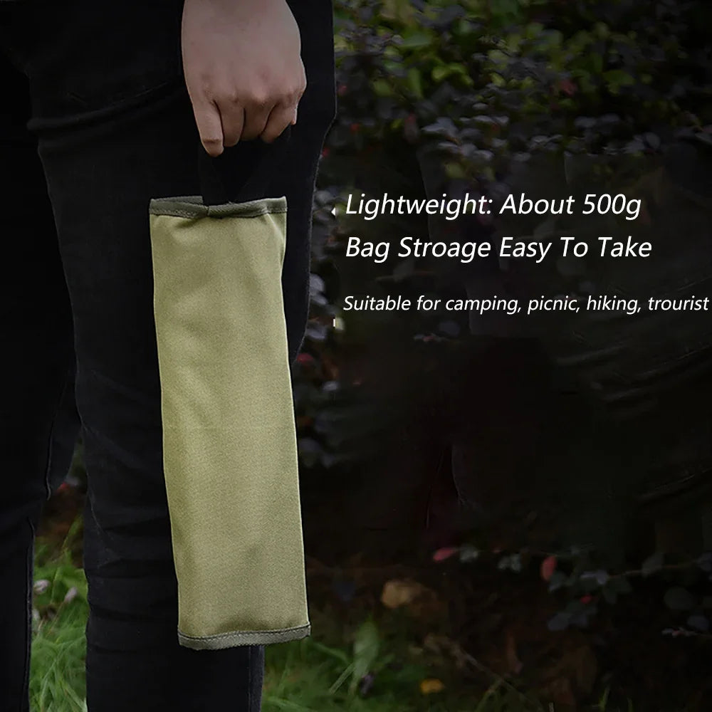 a man holding a skateboard in front of a bush