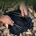 a person is holding a black suitcase with a handle