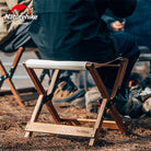 a man sitting on a bench in a dirt field