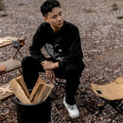 a man is sitting on a wooden bench 