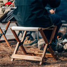 a man sitting on a bench in a dirt field 