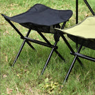 a black umbrella sitting on top of a lawn chair 